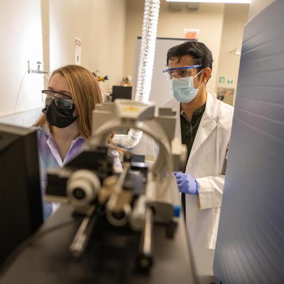 两名学生戴着口罩在实验室工作
